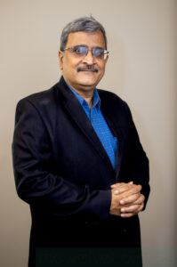 Professional corporate headshot of businessman in formal attire with clean background