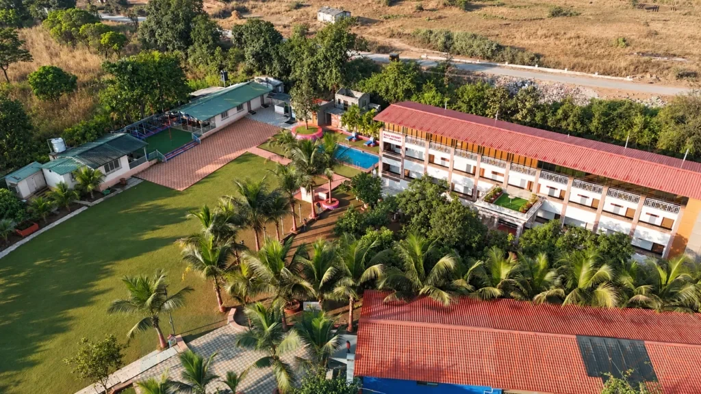 Aerial drone photograph showing resort architecture, pool and landscaped grounds