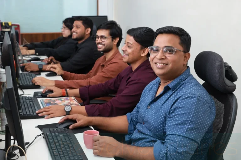Corporate office team photography showing employees seated at computer workstations, working together in a professional office environment in Mumbai.