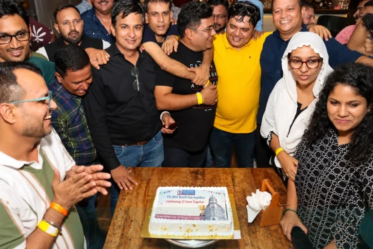 Corporate event photography capturing Central Bank of India PO 2011 batch members celebrating their 15-year reunion around a commemorative cake.