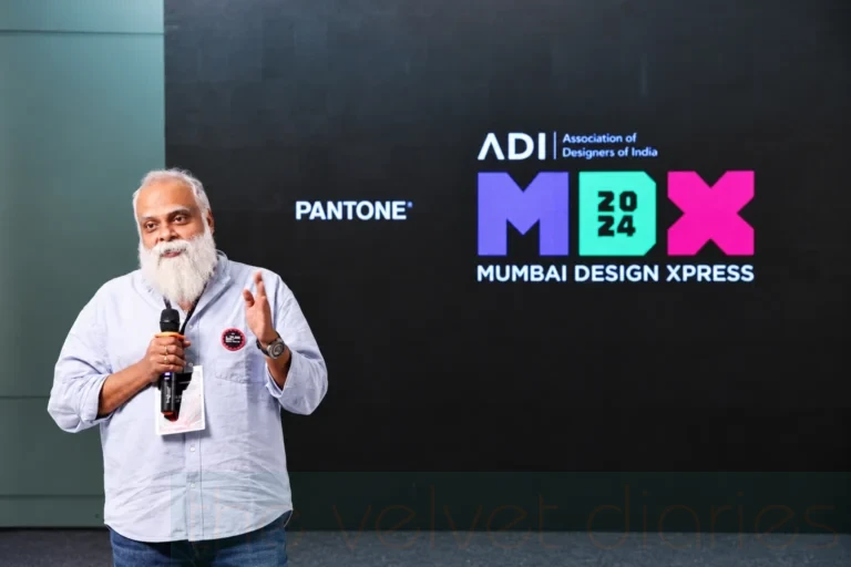 Corporate speaker event photography capturing a presenter addressing attendees at ADI Mumbai Design Xpress 2024, with event branding displayed on stage.