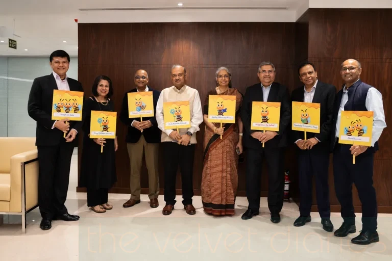 Corporate team photography showing senior professionals holding illustrated value cards during an employee engagement activity at an indoor corporate gathering.