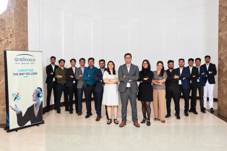 Corporate team portrait photography featuring Axe Finance employees in formal business attire, arranged around a central team member against a branded backdrop.