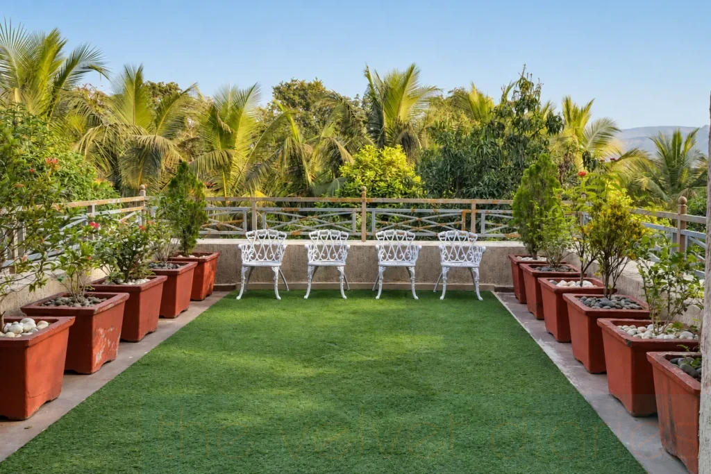Hospitality outdoor space photography featuring white garden chairs, symmetrical planters and tropical greenery in a landscaped resort seating area.