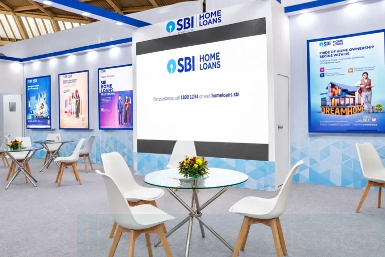 Exhibition booth photography showcasing the SBI Home Loans display interior, branded promotional panels, consultation tables and visitor seating at a property expo.