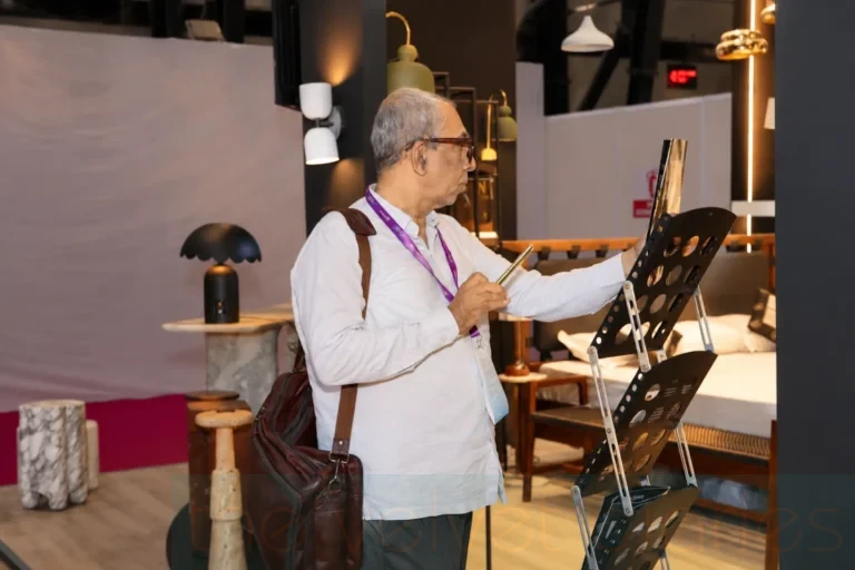 Visitor examining furniture and product displays at a furniture and design trade exhibition.